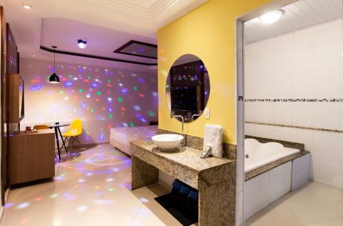 uma casa de banho com uma banheira e um lavatório num quarto em Motel Maresias - Radial Leste em São Paulo