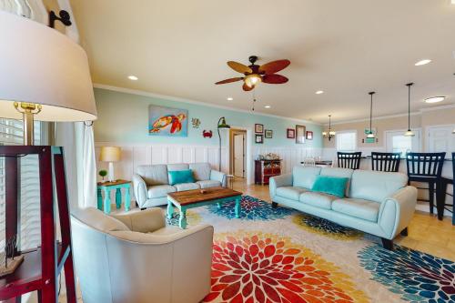 a living room with couches and a ceiling fan at Nightingale in Dauphin Island