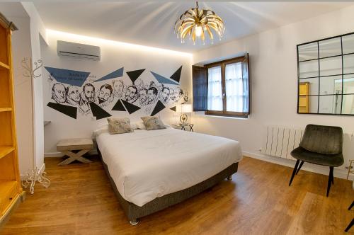 um quarto com uma cama grande e uma cadeira em Cervantes 5 Collection - Greco Aparcamiento en el Edificio em Toledo