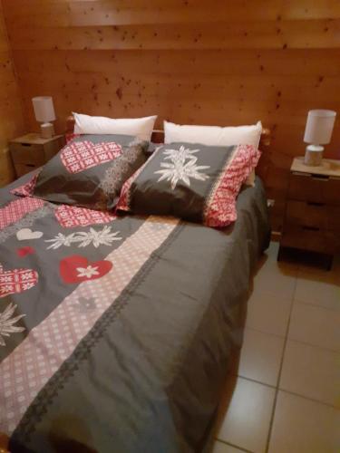 een slaapkamer met 2 bedden en kussens erop bij chalet des Greunnouilles in Xonrupt-Longemer