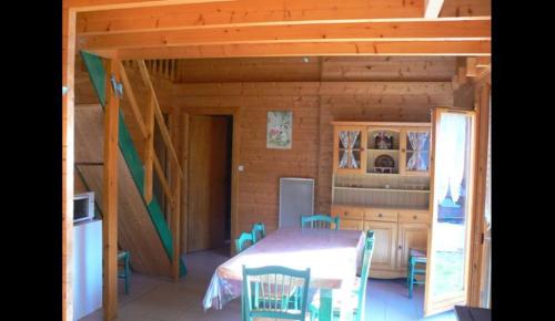 een keuken met een tafel en stoelen in een huisje bij chalet des Greunnouilles in Xonrupt-Longemer