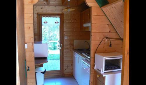 a small kitchen with a stove and a microwave at chalet des Greunnouilles in Xonrupt-Longemer