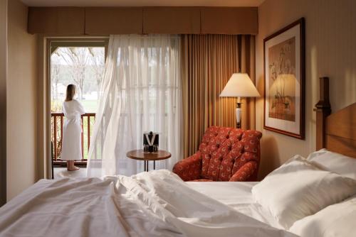 a hotel room with a bed and a chair and a window at St. Eugene Golf Resort & Casino in Cranbrook