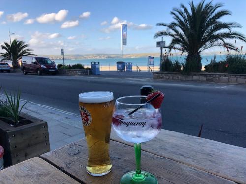 a glass of beer on a table with a strawberry in it at Beachcomber Guesthouse in Weymouth