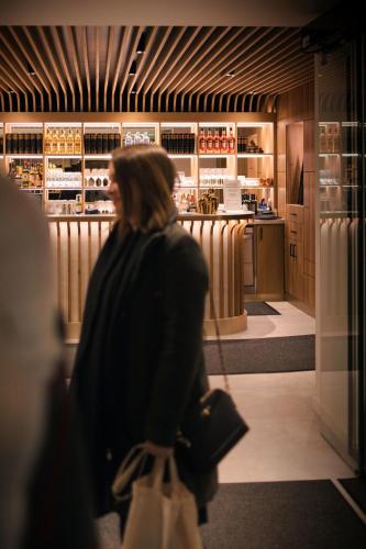 a woman walking through a store with a purse at Das Kronberg Hotel - Adults Only - inkl Soft- und Heißgetränkeflat in Bodenmais
