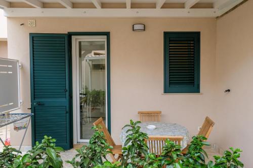 d'une terrasse avec une porte verte et une table. dans l'établissement BORGHETTO DEL SALENTO, à Uggiano la Chiesa