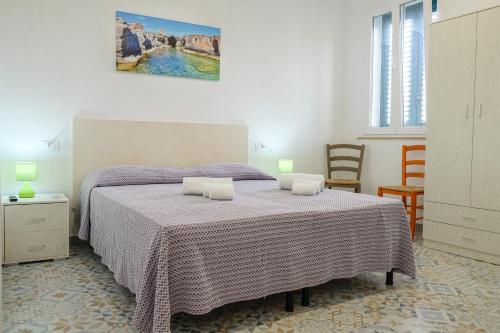 a bedroom with a bed with a purple blanket at BORGHETTO DEL SALENTO in Uggiano la Chiesa