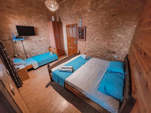 sypialnia z 2 niebieskimi łóżkami i telewizorem w obiekcie River house Velero w Ulcinju