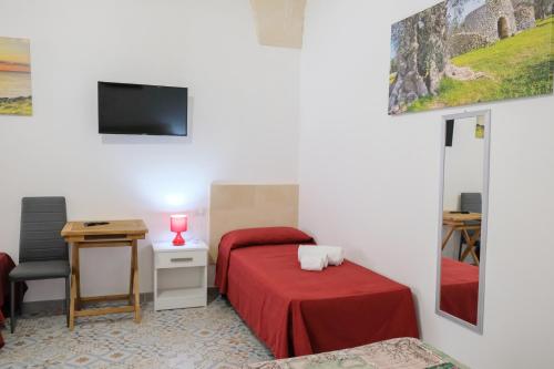 um quarto com uma cama, uma secretária e uma televisão em BORGHETTO DEL SALENTO em Uggiano la Chiesa