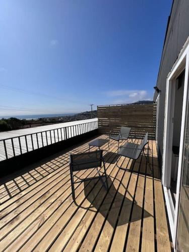 three chairs on a deck with a view of the beach at Cabaña Espectacular Maitencillo in Valparaíso
