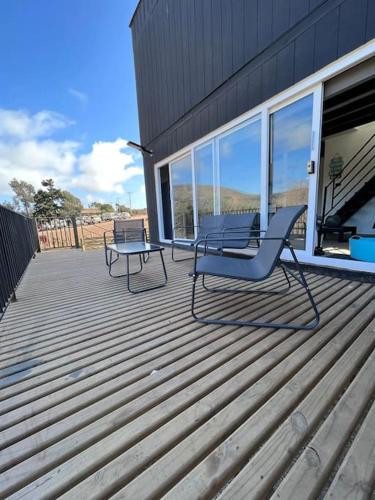 two chairs and a table sitting on a deck at Cabaña Espectacular Maitencillo in Valparaíso