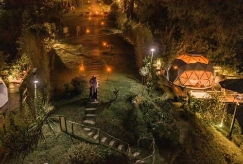 a man standing on a stairway in a park at night at Domus Glamping Guatapé in Guatapé
