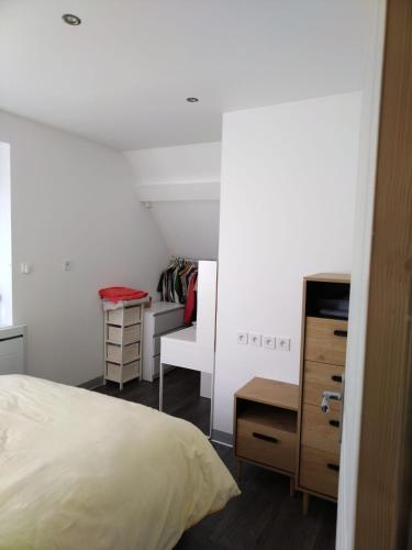 a bedroom with a bed and a dresser and a desk at Duplex Tressange in Tressange