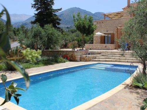 uma piscina em frente a uma casa em Villa Ariadne em Melidhónion
