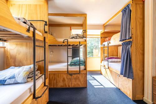 a room with bunk beds in a house at The Flaming Kiwi Backpackers in Queenstown