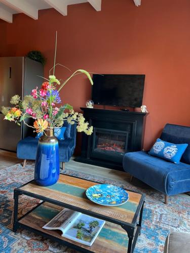 a living room with a blue couch and a fireplace at Guesthouse by C in Colijnsplaat