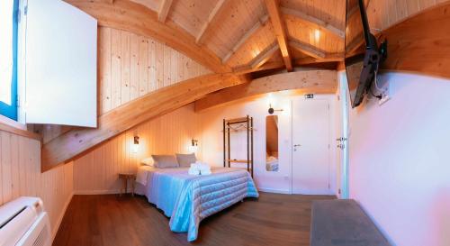 蓬蒂迪利馬的住宿－Blue House Ponte de Lima，一间带一张床的卧室,位于带木制天花板的房间内