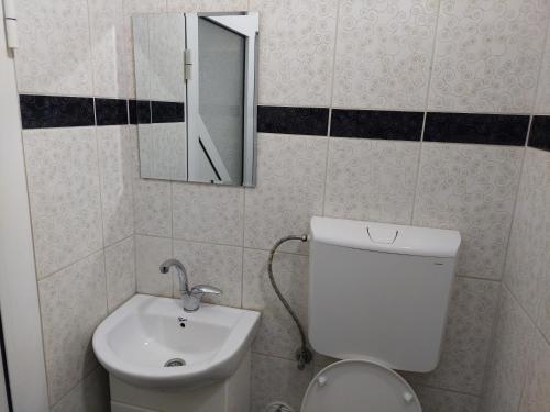 a bathroom with a white toilet and a sink at Apartman Aleksić u samom centru grada in Knjazevac.