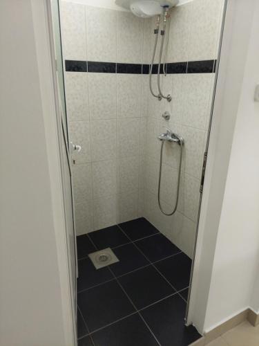 a bathroom with a shower with a black and white tiled floor at Apartman Aleksić u samom centru grada in Knjazevac.