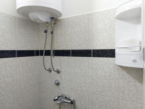 y baño con ducha con cabezal de ducha. en Apartman Aleksić u samom centru grada en Knjazevac.