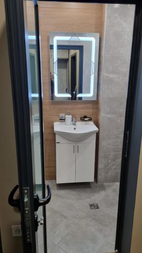 W łazience znajduje się biała umywalka i lustro. w obiekcie Premium Lux apartment w mieście Montana