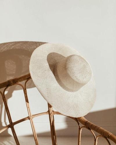 a white hat sitting on top of a chair at KeRo Luxury Rooms in Cagliari