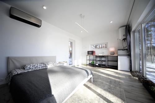 a bedroom with a bed and a large window at GaujaClub - our BOSE and Bang&Olufsen lofts on a lake in Gauja