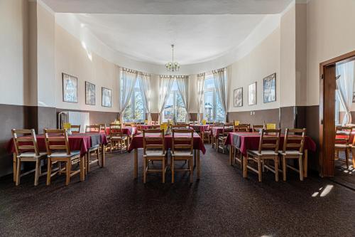 una sala da pranzo con tavoli e sedie in una stanza di Penzión Poľana a Vysoke Tatry - Horny Smokovec