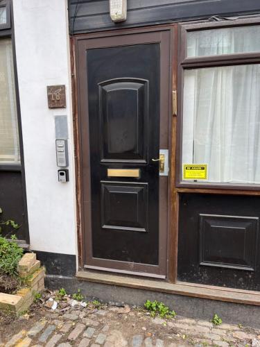 a black door on a house with a window at Studio flat in the heart of Golders Green in London