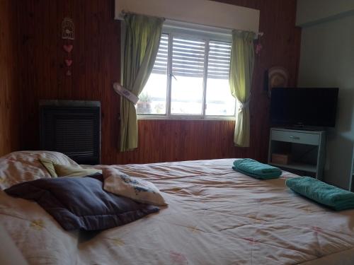 Un dormitorio con una cama grande con almohadas. en Departamento en Comodoro Rivadavia