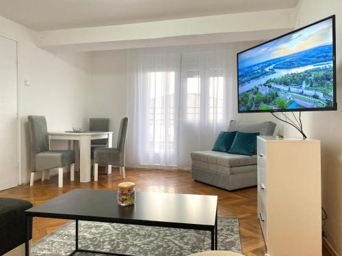 a living room with a couch and a tv on the wall at Panorama Royal Vračar in Vračar (historical)