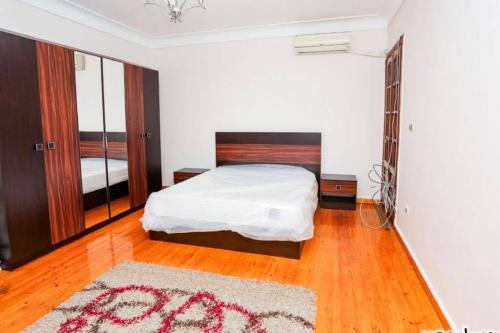 ein Schlafzimmer mit einem weißen Bett und einem Teppich in der Unterkunft Adorable Unique Furniture Flat in Alexandria