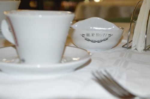 a table with a cup and a bowl and forks at Motel Buti in Sighetu Marmaţiei