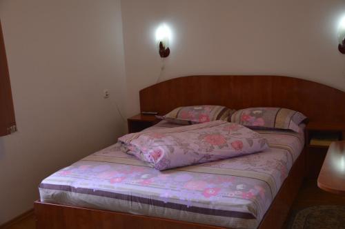 a bedroom with a bed with a wooden headboard at Motel Buti in Sighetu Marmaţiei