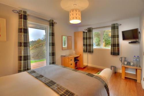 een slaapkamer met een bed en een raam bij Aspen Lodge in Oban