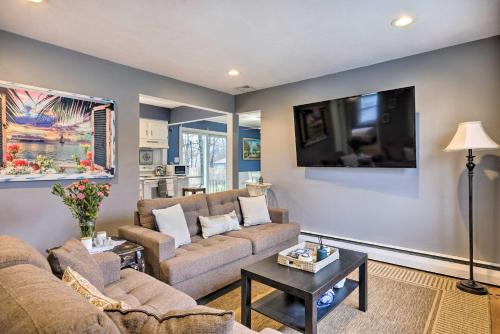 a living room with two couches and a flat screen tv at Charming Rocky Point Home about 1 Mi to Beach! in Rocky Point