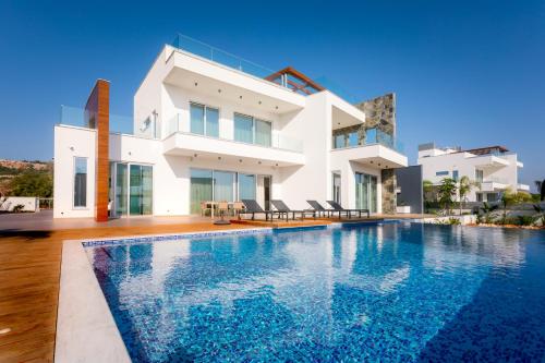 a villa with a swimming pool in front of a house at Sea Pearl Beachfront Villas - Anemone in Ayia Napa