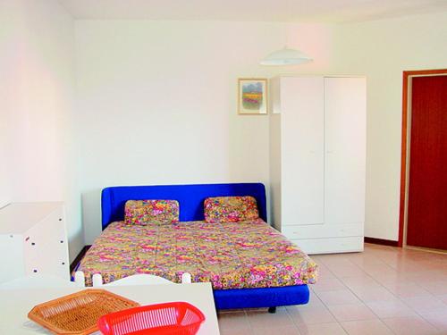 a bedroom with a blue bed and a red cabinet at Flat in Lignano Sabbiadoro in Lignano Sabbiadoro