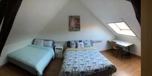 1 dormitorio en el ático con 2 camas y escritorio en Gite Sologne, en Marcilly-en-Gault
