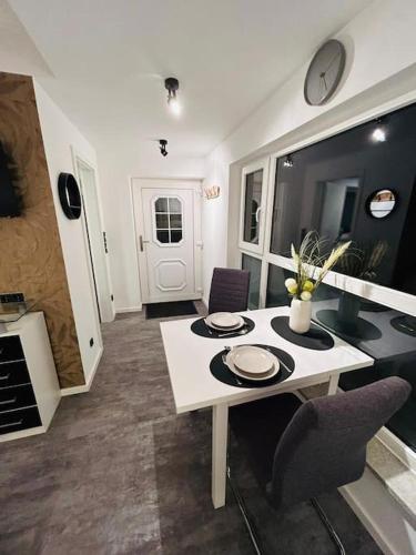 ein Wohnzimmer mit einem weißen Tisch und Stühlen in der Unterkunft Bezauberndes Apartment im Herzen von Nieukerk. in Kerken