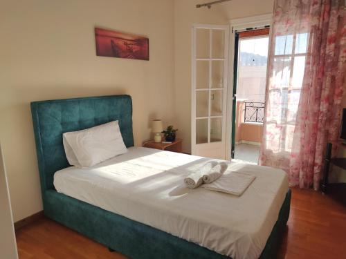een slaapkamer met een bed met een groen hoofdeinde bij San Vlassis Area Apartment in Lákones