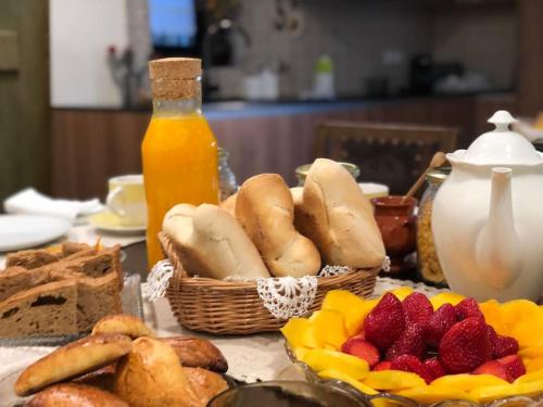 a table with baskets of bread and fruit and a bottle of orange juice at New Honey House, Serra do Marão Ansiães-Amarante in Amarante