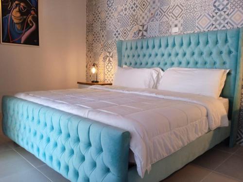 a blue bed with a blue headboard in a bedroom at Hotel Mono Azul in Quepos
