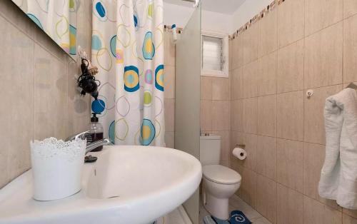 a bathroom with a sink and a toilet and a shower curtain at Apartamento en Los Gigantes, Tenerife in Puerto de Santiago