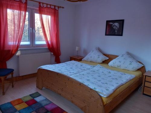 um quarto com uma cama de madeira e 2 janelas em Ferienwohnung Rathke em Sorge