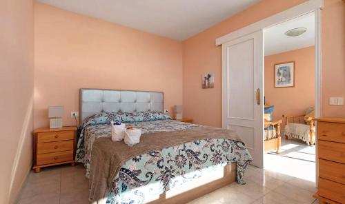 a bedroom with a bed with two cats sitting on it at Apartamento en Los Gigantes, Tenerife in Puerto de Santiago