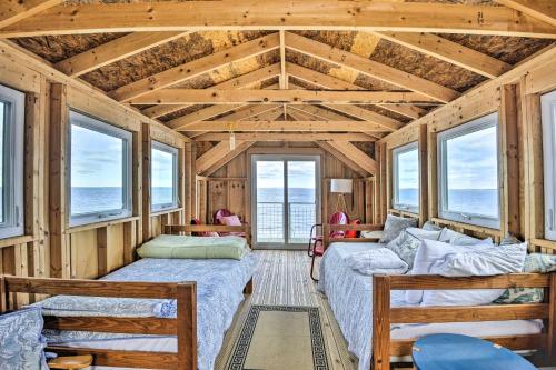 uma sala de estar com duas camas e janelas em Henderson Harbor Cottage with Lake Access! em Sackets Harbor