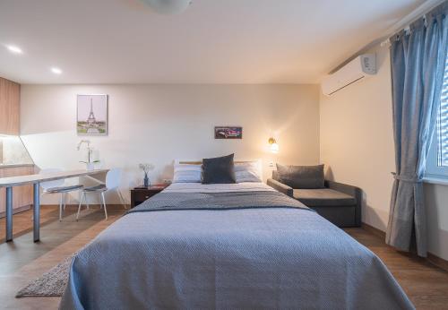 1 dormitorio con cama, mesa y escritorio en Gynėjų Apartments - Lollo Luxury, en Vilna