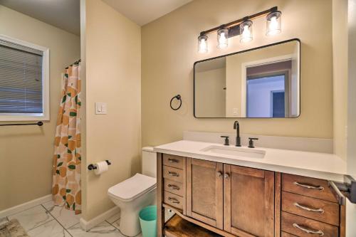 a bathroom with a sink and a mirror and a toilet at Pocono Vacation Rental with Movie Room and Hot Tub! in East Stroudsburg