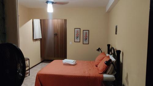 a bedroom with a bed with a red blanket at Angra dos Reis, Bonfim Cond Refúgio do Corsário in Angra dos Reis